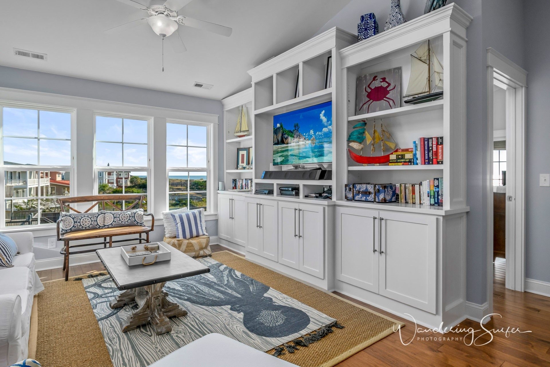 Bright coastal living room with built-in shelving photographed for a real estate listing